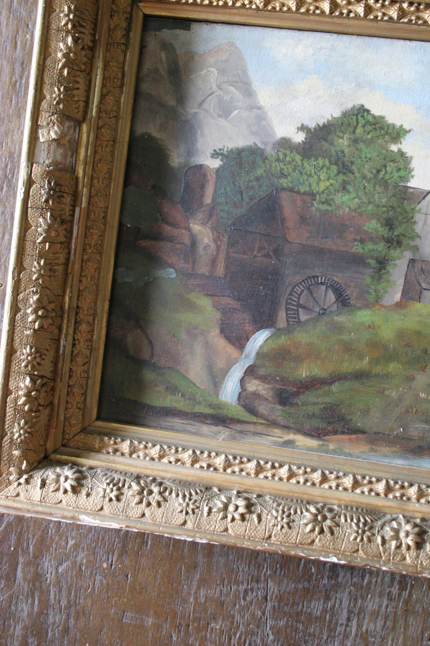 Antique landscape oil painting on board in gilded floral frame