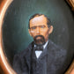 Antique portrait of man on board in gilded frame
